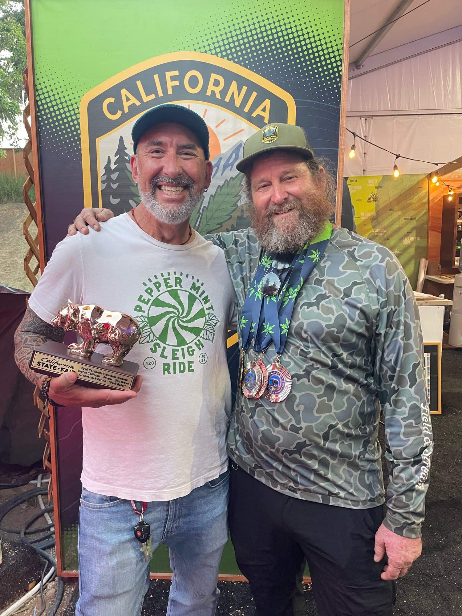 Mark Greyshock and a guest with the Golden Bear trophy