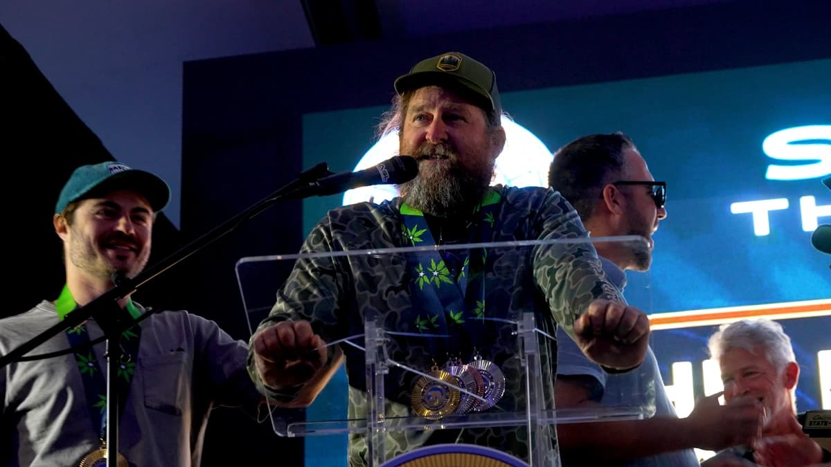 Mark Greyshock at the podium after Pink Rider’s 2026 Golden Bear, medals on the green ribbon.