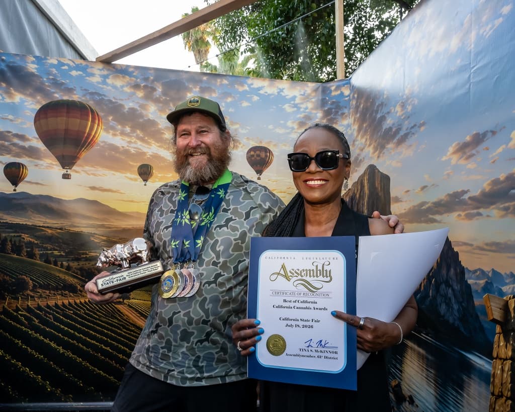 Mark Greyshock with Assemblymember Tina McKinnor and the 2026 Golden Bear trophy for Pink Rider.